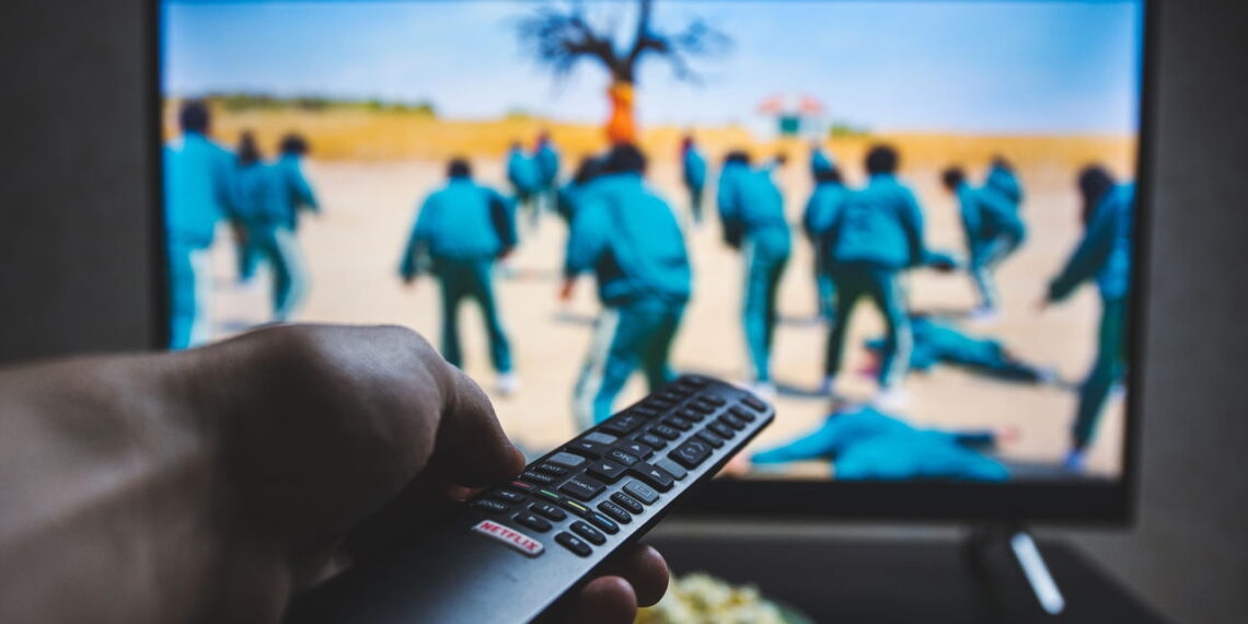 Watching Squid game show on TV. Squid game is a South Korean survival drama television series streaming on Netflix