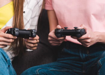 Pessoas jogando em console - Créditos: depositphotos.com / AndrewLozovyi