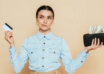 Mulher pensativa sobre dinheiro - Créditos: depositphotos.com / IgorVetushko