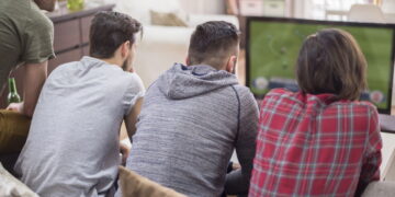 Homens assistindo jogo de futebol - Créditos: depositphotos.com / gpointstudio