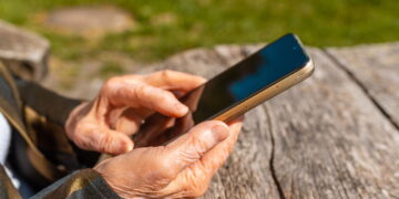 Idoso segurando o celular- Créditos: depositphotos.com / arvydele.gmail.com