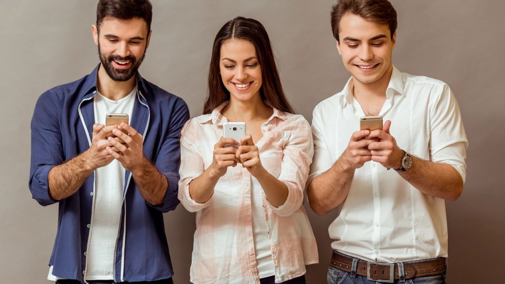 Jovens usando celular - Créditos: depositphotos.com / GeorgeRudy