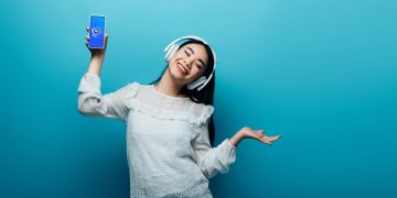 Moça ouvindo música no Shazam - Créditos: depositphotos.com / HayDmitriy