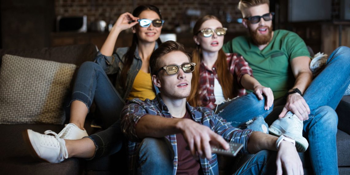 Amigos vendo tv - Créditos: depositphotos.com / TarasMalyarevich