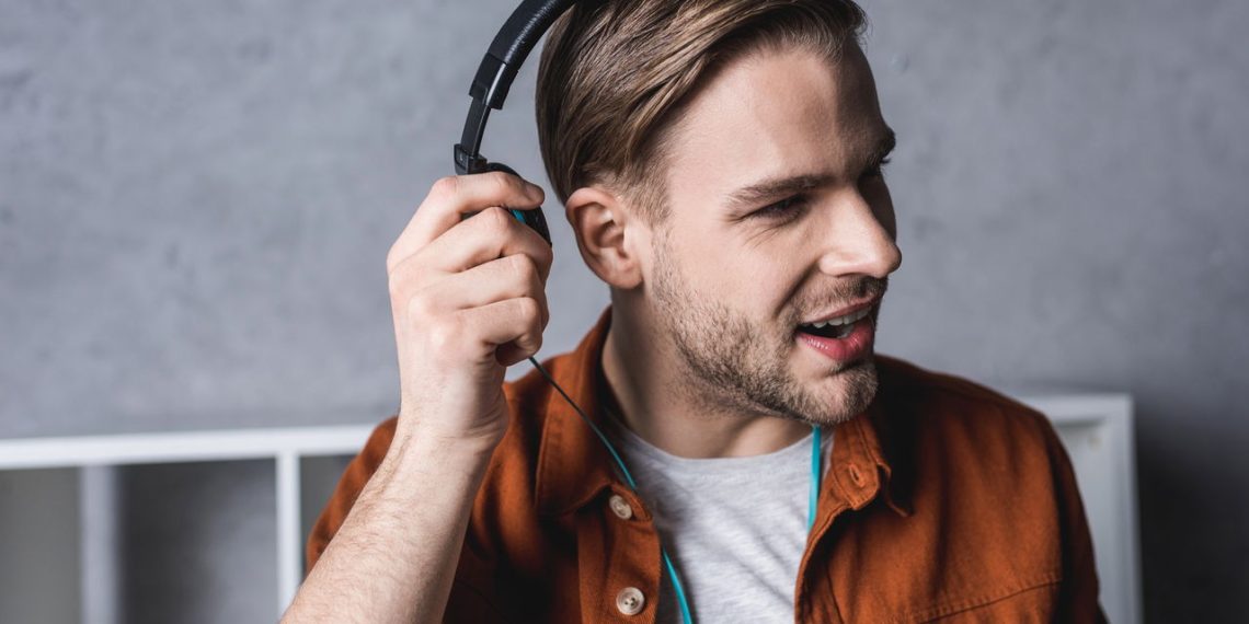Homem usando Headphone - Créditos: depositphotos.com / SarkisSeysian