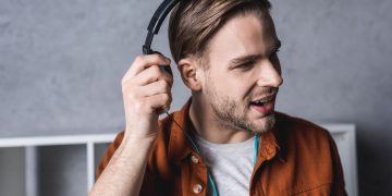 Homem usando Headphone - Créditos: depositphotos.com / SarkisSeysian