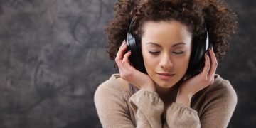 Mulher ouvindo música em fone - Créditos: depositphotos.com / stokkete