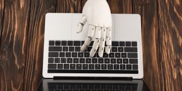 Braço de robô e laptop - Créditos: depositphotos.com / VitalikRadko