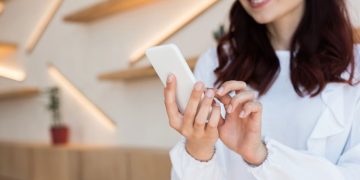 Moça olhando celular - Créditos: depositphotos.com / AllaSerebrina