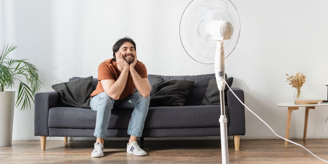 Homem de frente ao ventilador - Créditos: depositphotos.com / Ischukigor