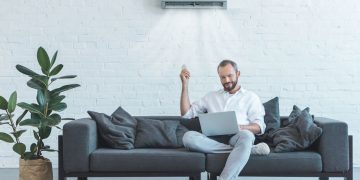 Homem ligando ar-condicionado - Créditos: depositphotos.com / AllaSerebrina