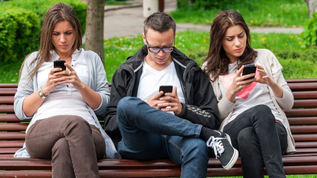 Pessoas utilizando celular - Créditos: depositphotos.com / vladteodor95