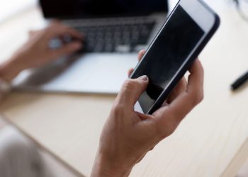 Mulher com laptop e smartphone - Créditos: depositphotos.com / AllaSerebrina