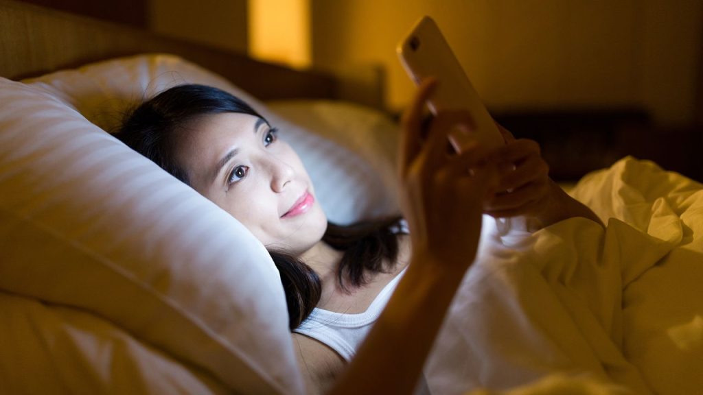 Usando celular na hora do sono - Créditos: depositphotos.com / leungchopan