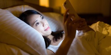 Usando celular na hora do sono - Créditos: depositphotos.com / leungchopan