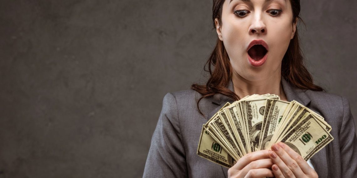 Mulher com vários dólares na mão - Créditos: depositphotos.com / HayDmitriy