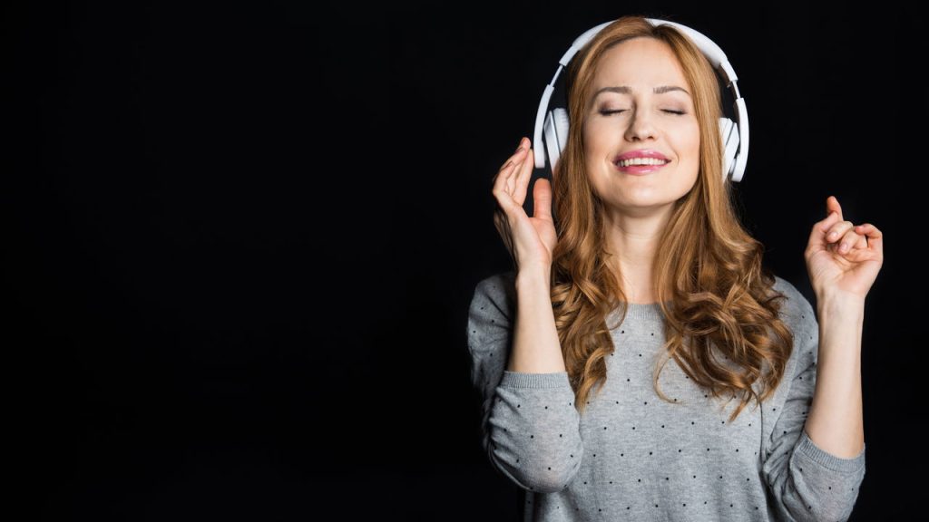 Mulher ouvindo música - Créditos: depositphotos.com / IgorTishenko