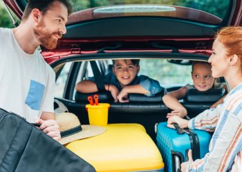 Família colocando itens em porta-malas de carro - Créditos: depositphotos.com / alebloshka