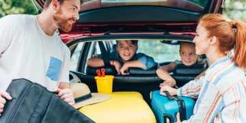 Família colocando itens em porta-malas de carro - Créditos: depositphotos.com / alebloshka