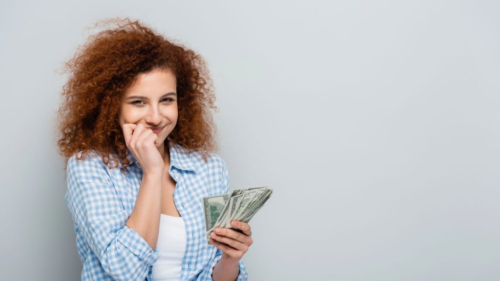 Mulher com dinheiro nas mãos - Créditos: depositphotos.com / HayDmitriy