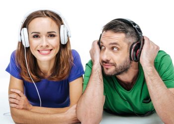 Homem e mulher escutando música com headset - Créditos: depositphotos.com / AndrewLobov