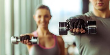 Casal com halteres na mão - Créditos: depositphotos.com / GeorgeRudy