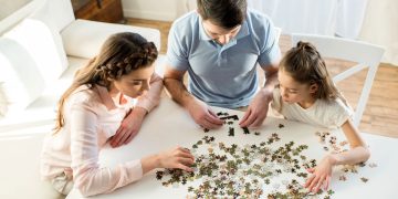 Pessoas montando quebra-cabeça - Créditos: depositphotos.com / NatashaFedorova