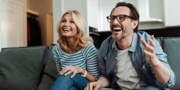 Casal assistindo e rindo - Créditos: depositphotos.com / AndrewLozovyi