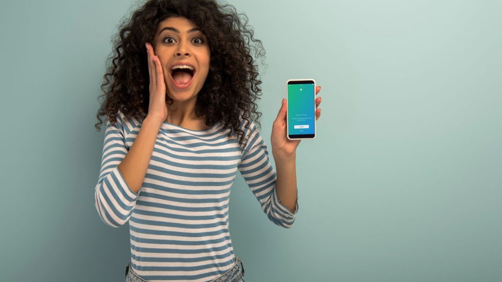 Representação de jovem surpresa com notícia de Twitter - Créditos: depositphotos.com / AndrewLozovyi