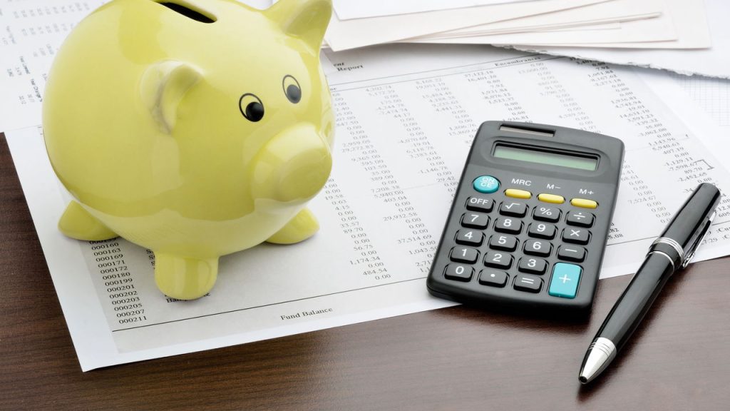 Cofrinho e contas na mesa - Créditos: depositphotos.com / pogonici