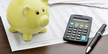 Cofrinho e contas na mesa - Créditos: depositphotos.com / pogonici