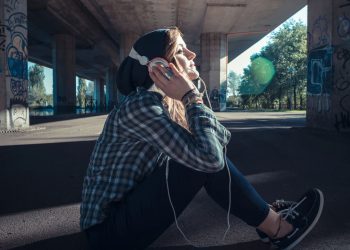 Moça escutando música - Créditos: depositphotos.com / peusa