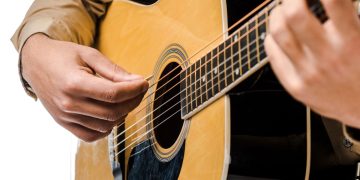 Homem tocando violão - Créditos: depositphotos.com / AndrewLozovyi