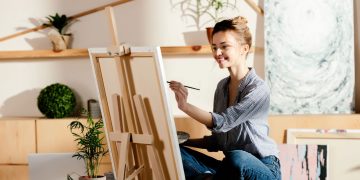 Mulher pintando em quadro - Créditos: depositphotos.com / IgorVetushko