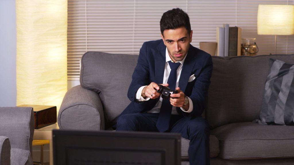 Homem passando tempo em videogame - Créditos: depositphotos.com / Mark Adams