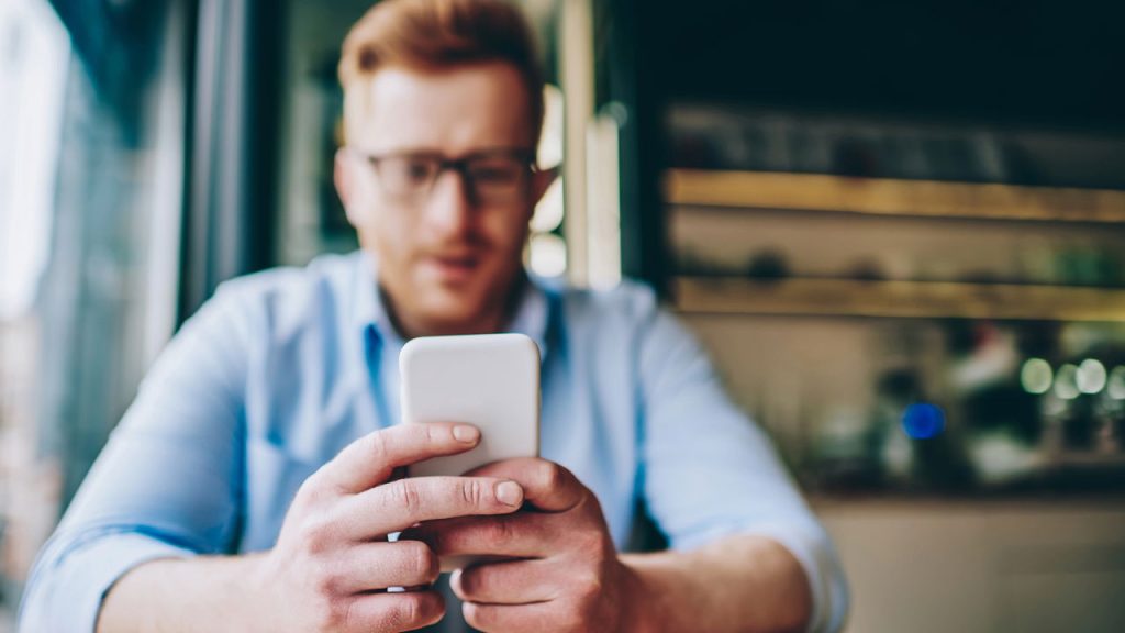 Homem usando celular - Créditos: depositphotos.com / GaudiLab