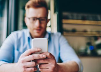 Homem usando celular - Créditos: depositphotos.com / GaudiLab