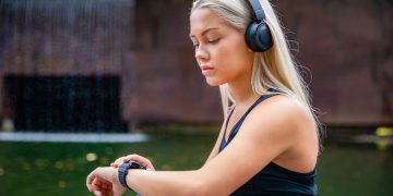 Mulher olhando smartwatch - Créditos: depositphotos.com / kjekol