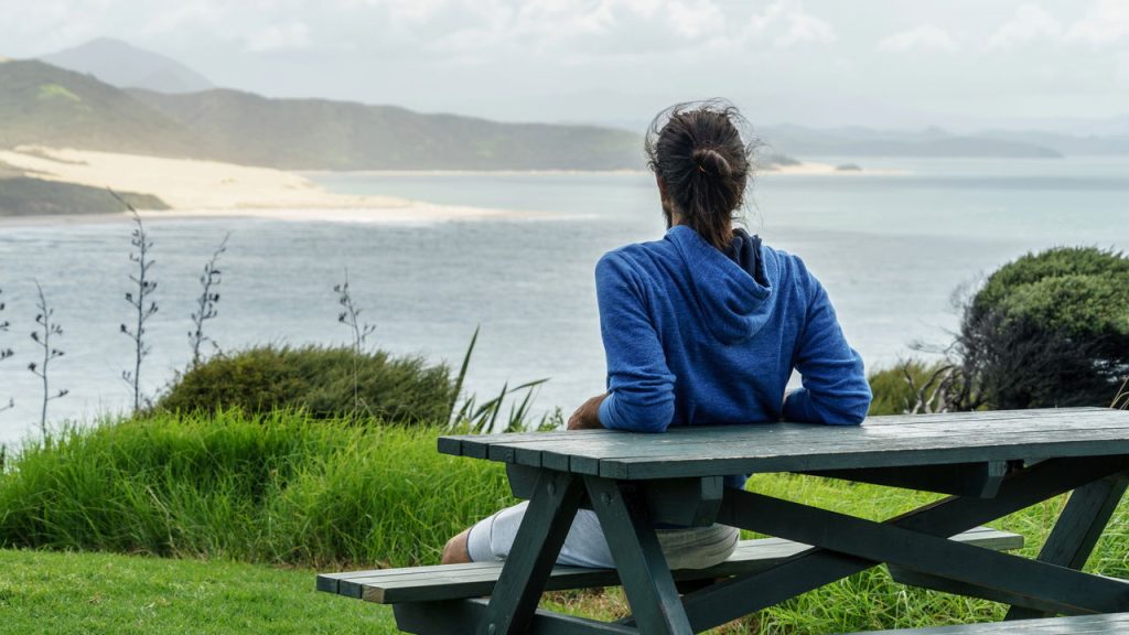 Homem olhando vista na praia - Créditos: depositphotos.com / OlgaSinenkoBO