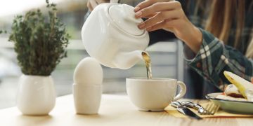 Colocando chá no copo - Créditos: depositphotos.com / ViktoriiaDyachenko