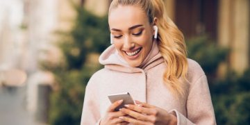 Mulher usando Airpods - Créditos: depositphotos.com / Milkos