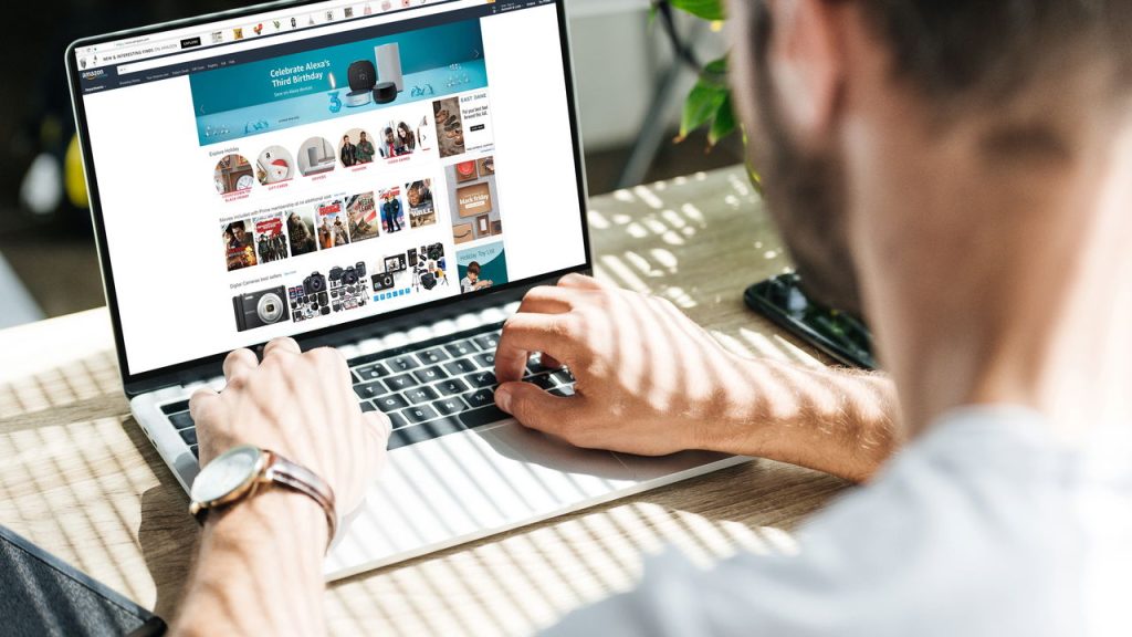 Homem acessando Amazon em laptop - Créditos: depositphotos.com / Y-Boychenko