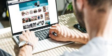 Homem acessando Amazon em laptop - Créditos: depositphotos.com / Y-Boychenko