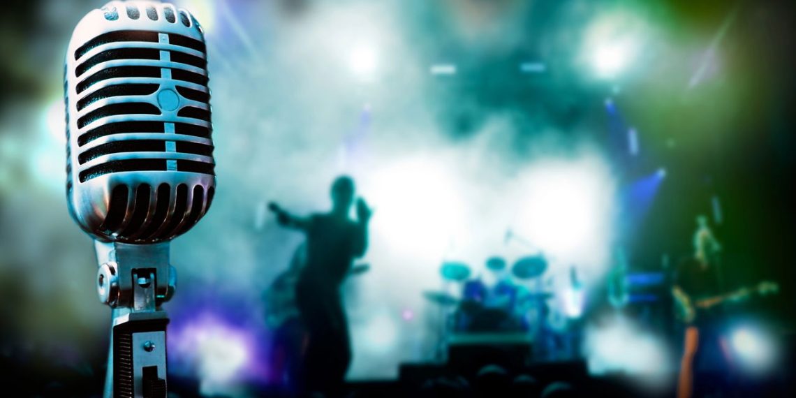 Microfone em fundo de palco musical - Créditos: depositphotos.com / carloscastilla