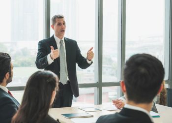 Homem falando em reunião de trabalho - Créditos: depositphotos.com / Nopphon1987