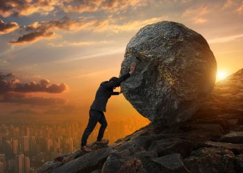 Homem empurrando pedra para cima - Créditos: depositphotos.com / chaiyapruek