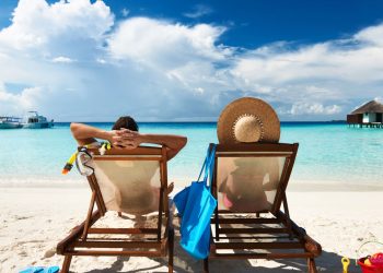 Casal deitado em cadeiras de praia - Créditos: depositphotos.com / haveseen