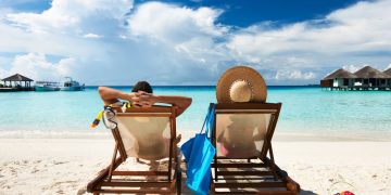 Casal deitado em cadeiras de praia - Créditos: depositphotos.com / haveseen