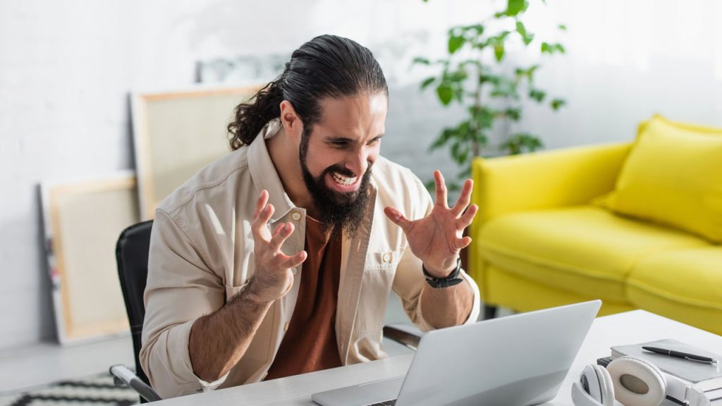 Homem irritado em laptop - Créditos: depositphotos.com / AndrewLozovyi