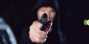 Criminoso apontando arma - Créditos: depositphotos.com / AndrewLozovyi